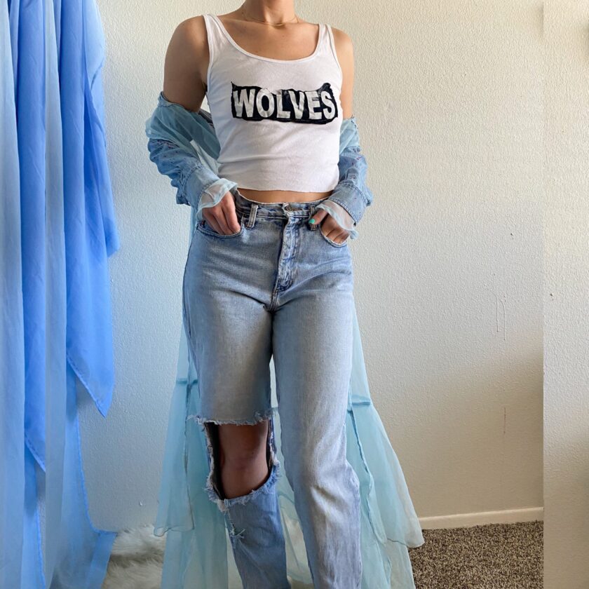 A woman wearing a 1of1 fairytale feels jacket and blue jeans.
