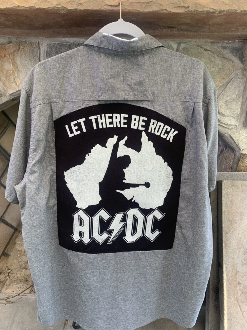 An AC/DC Let There Be Rock gray button up shirt with a black and white design on it.