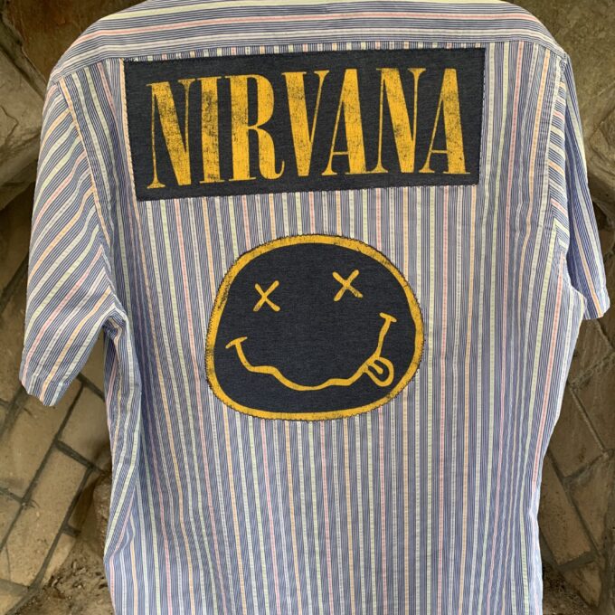 A Nirvana mens pinstriped button up shirt with a smiley face on it.