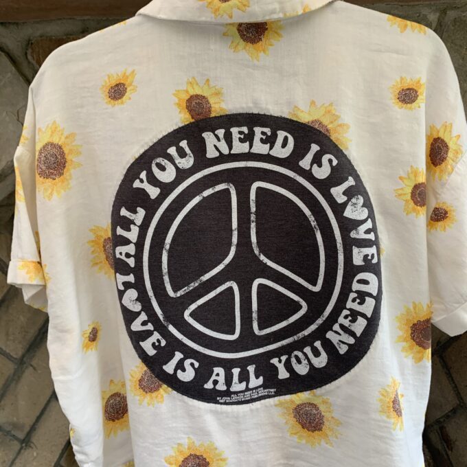 A white "All You Need Is Love" sunflower button-up shirt.