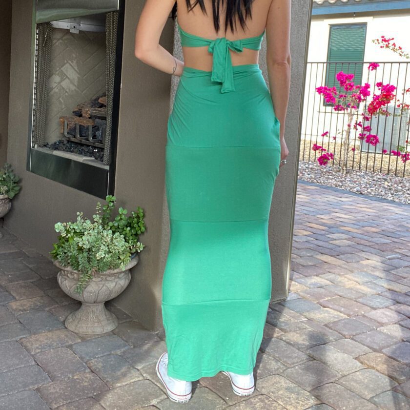 A woman in a 1of1 mint green maxi skirt is standing outside.