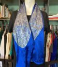 A mannequin wearing a hand-painted iridescent blue dragonfly wing scarf.