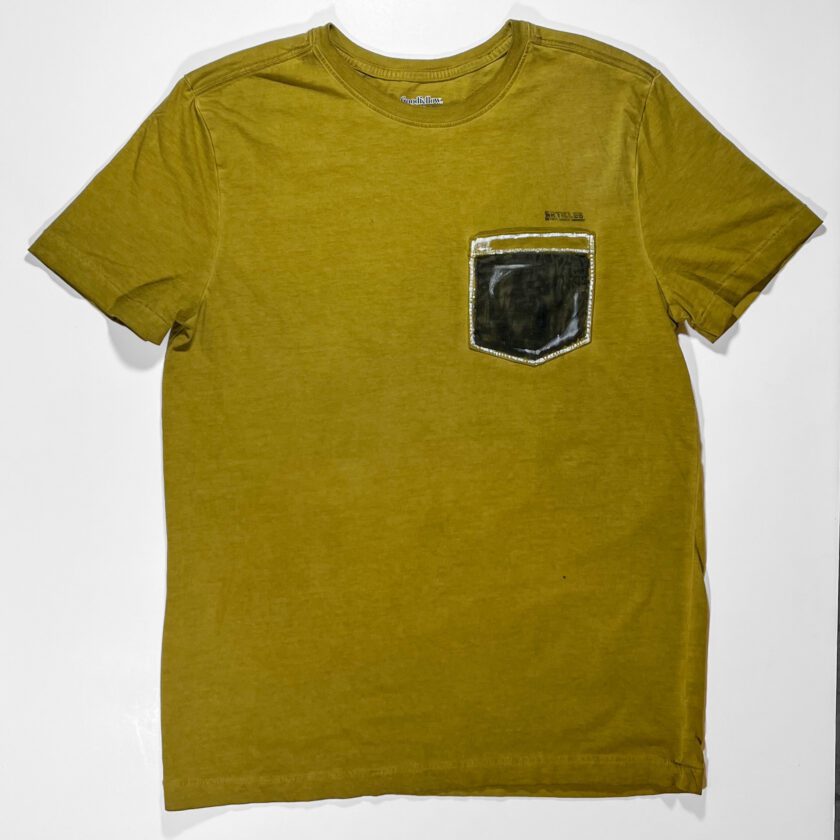 A yellow Color Me T-Shirt with a black pocket on it.