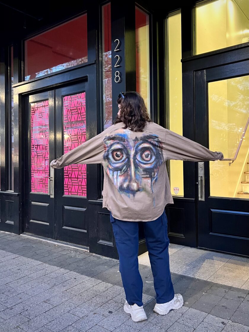 A person standing on a sidewalk with their arms outstretched in a Wide-Eyes Button-Down Shirt.