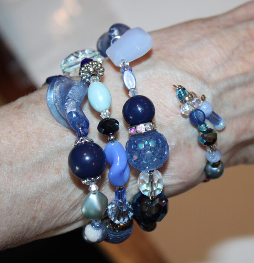 View of the blue bracelet on the wrist with charm dangle showing