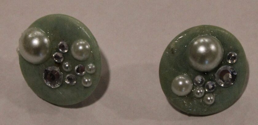 A pair of Light Green Stone Clip Earrings with Pearls and Rhinestones on them.