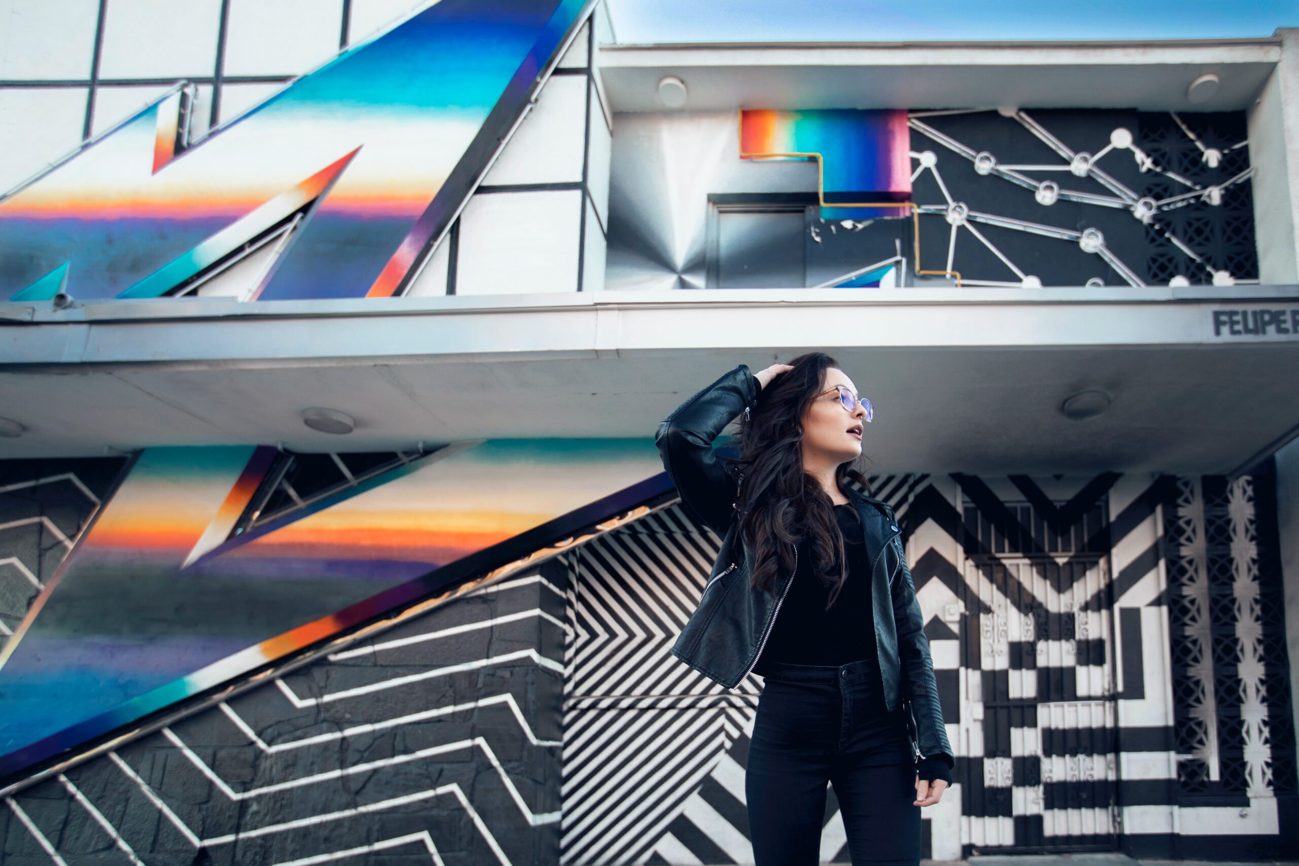 a woman standing in front of a colorful wall.