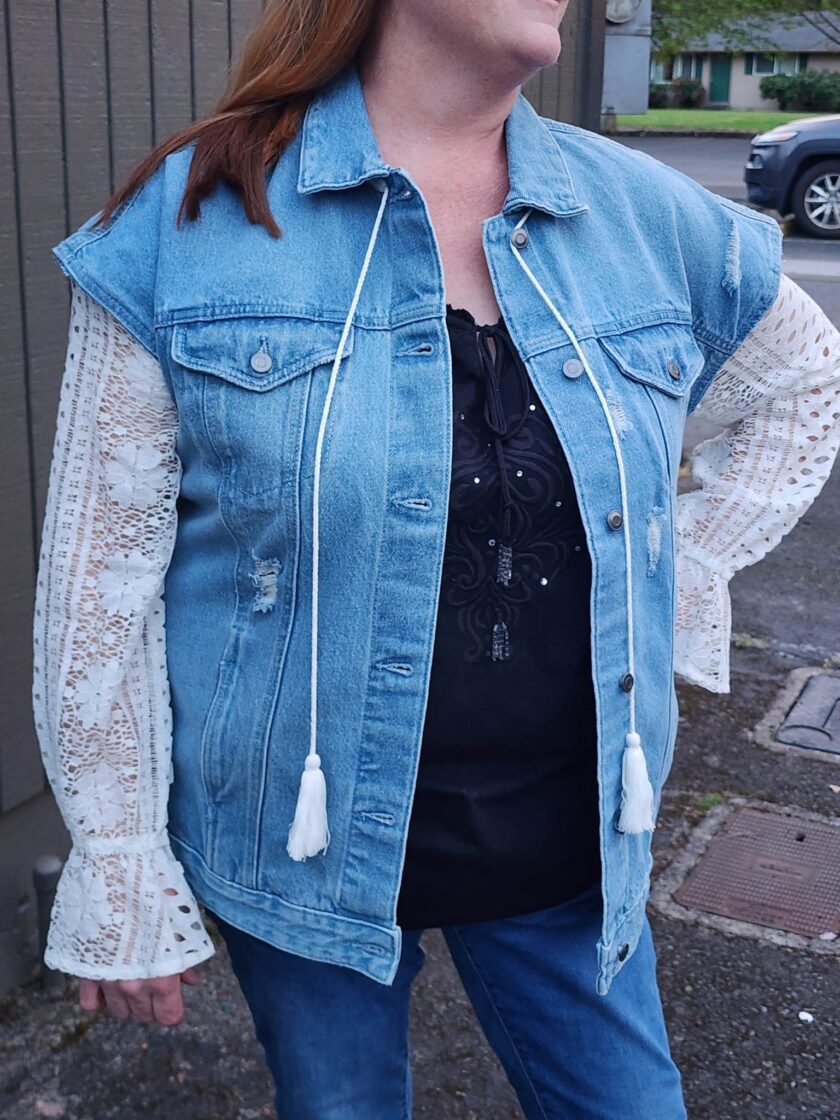 A woman wearing the Take Me To The Ocean upcycled denim & lace jacket.
