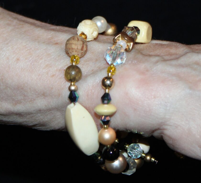 A view of a beaded bracelet featuring black jet and ivory colored beads wrapped around wrist
