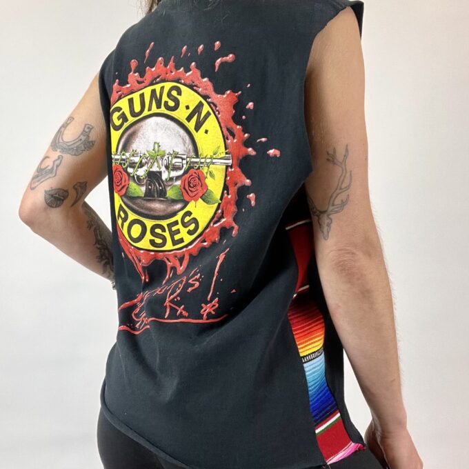 a woman wearing a tank top with a guns n roses design on it.