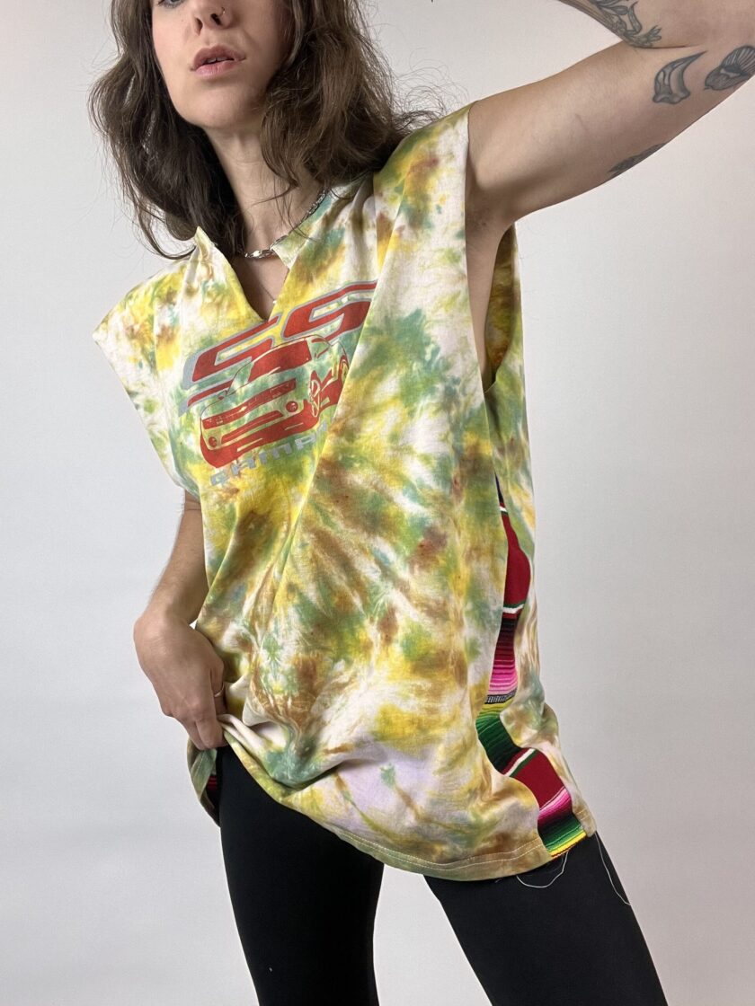 a woman in a tie dye shirt holding her hair.