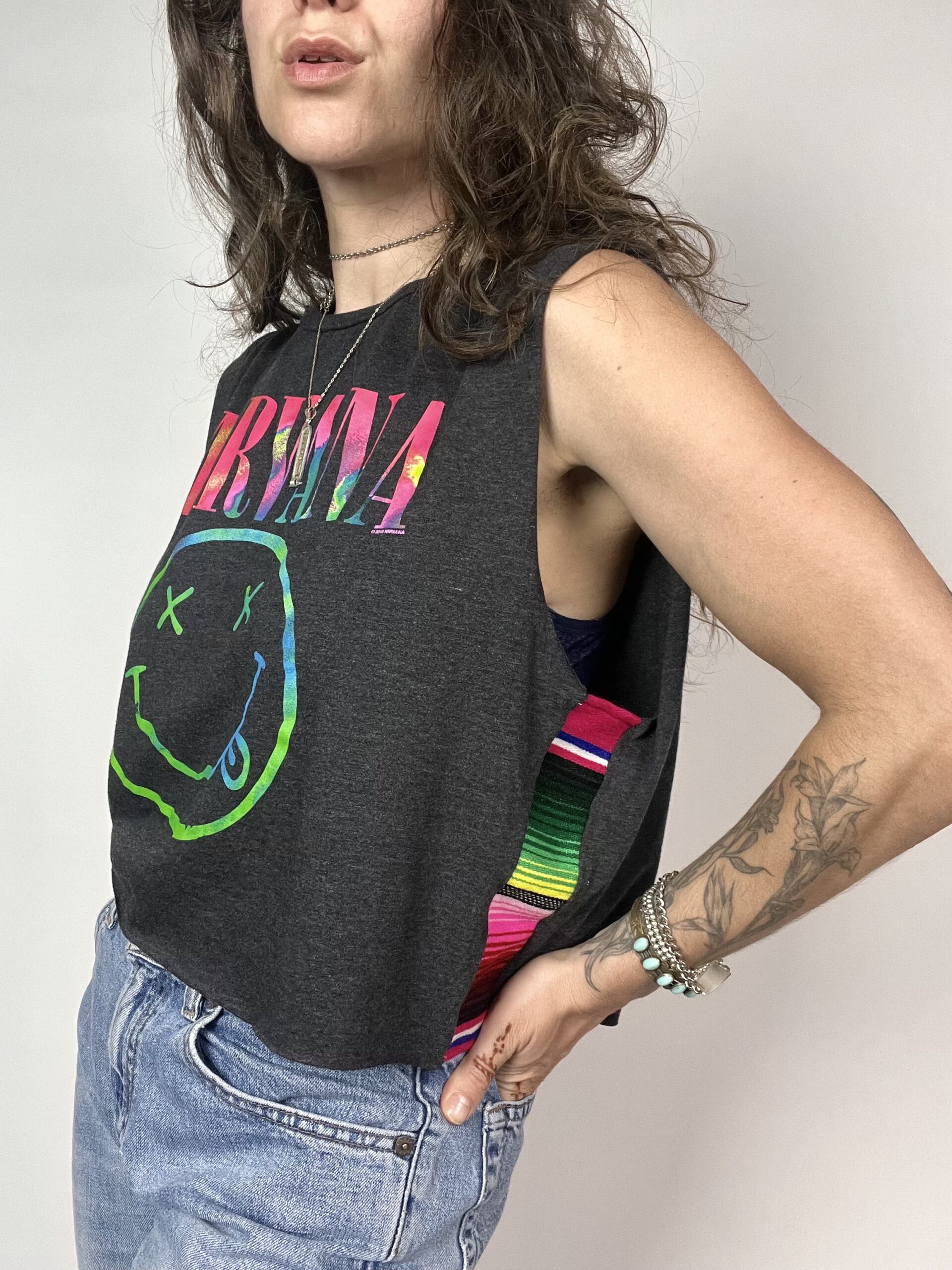 a woman wearing a tank top and jeans.
