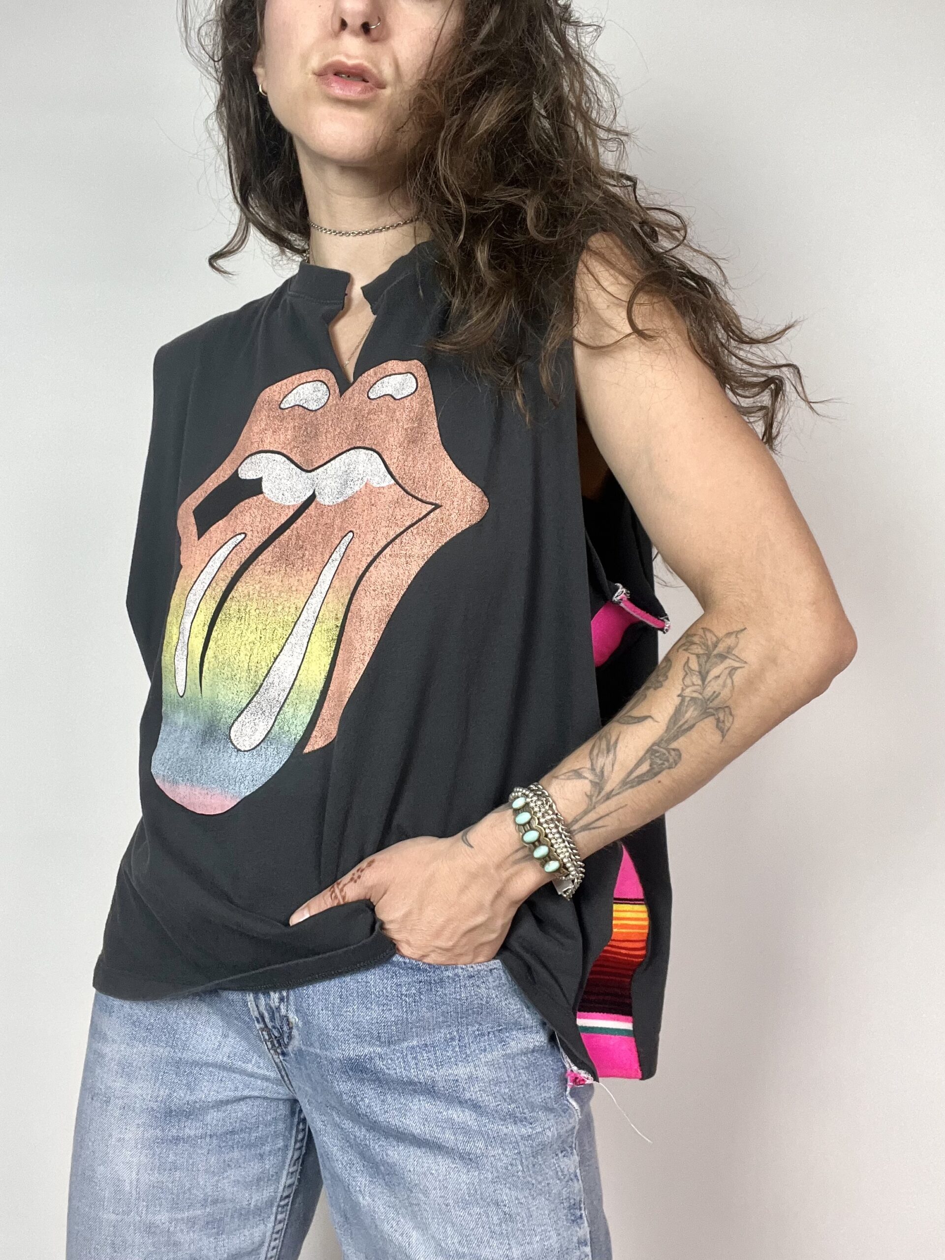 a woman with long hair wearing a black shirt with the rolling stones on it.