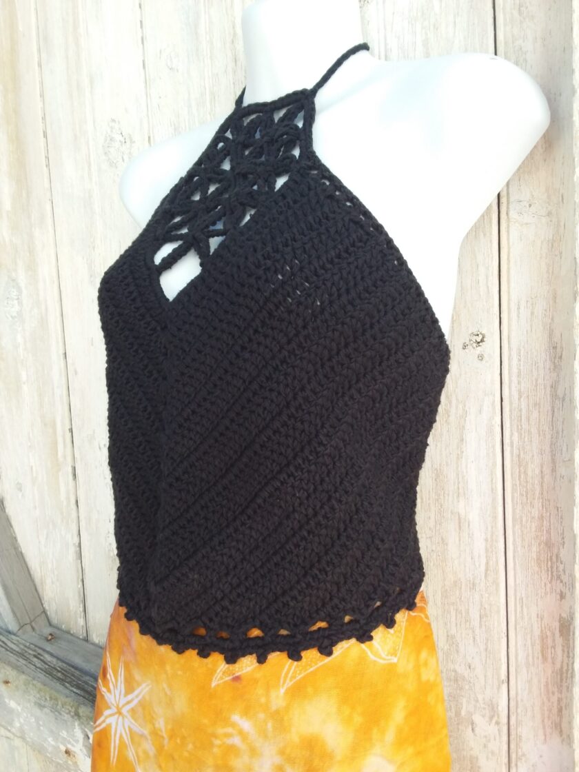 A black crochet halter top with picot edging paired with a bright orange skirt