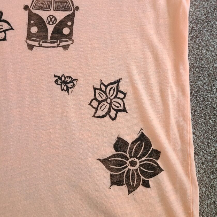 a pink t - shirt with flowers and a vw van on it.