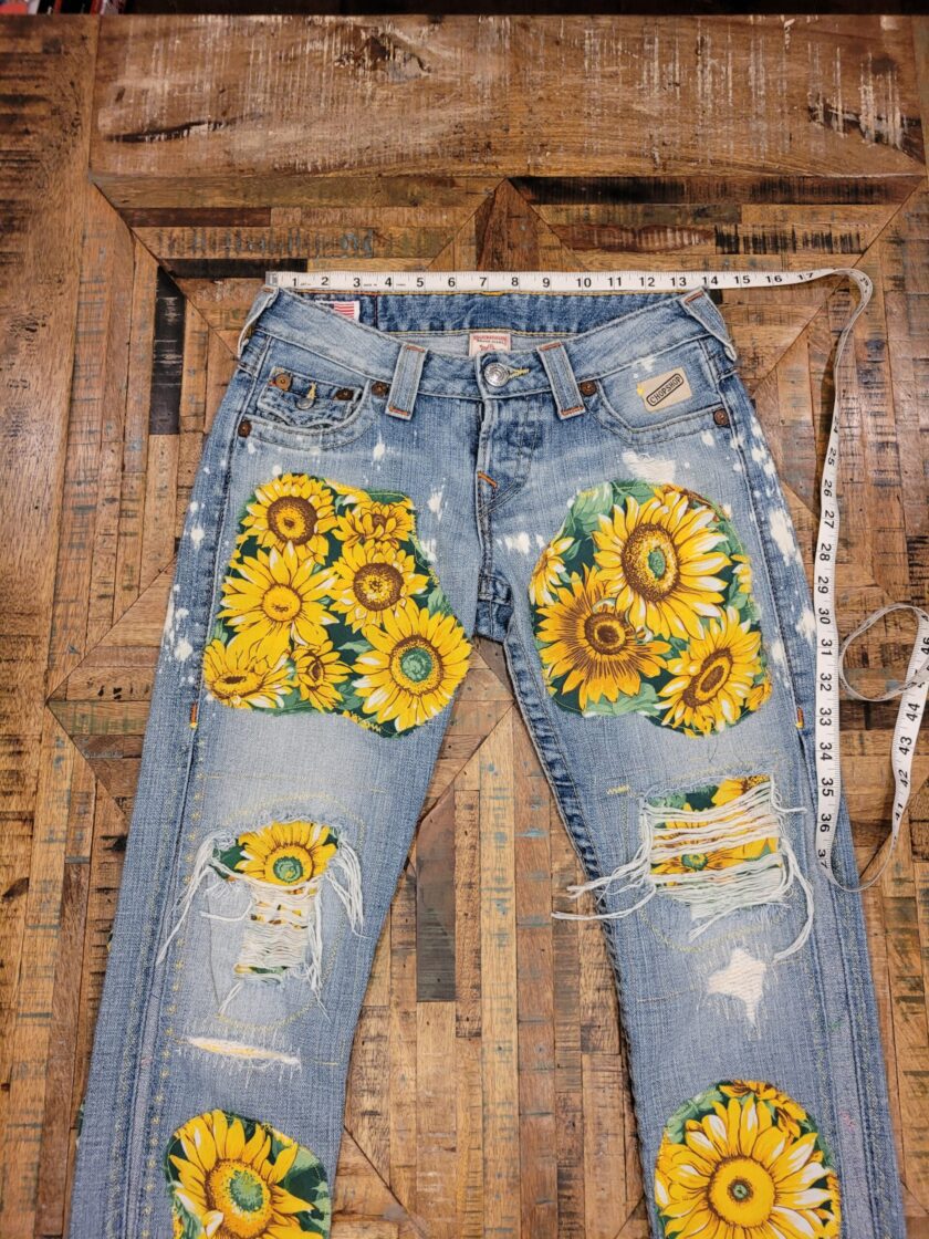 a pair of jeans with sunflowers on them.
