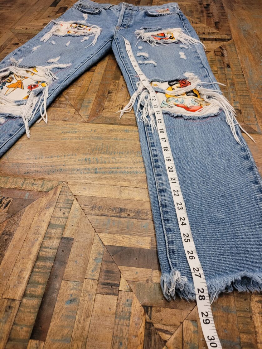 a pair of ripped jeans with a tape measure.