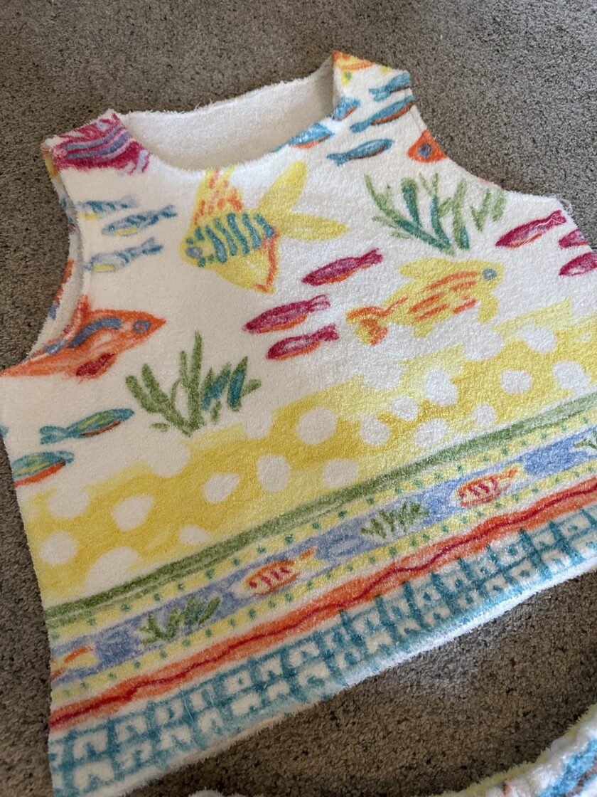 a baby vest with a colorful fish print on it.