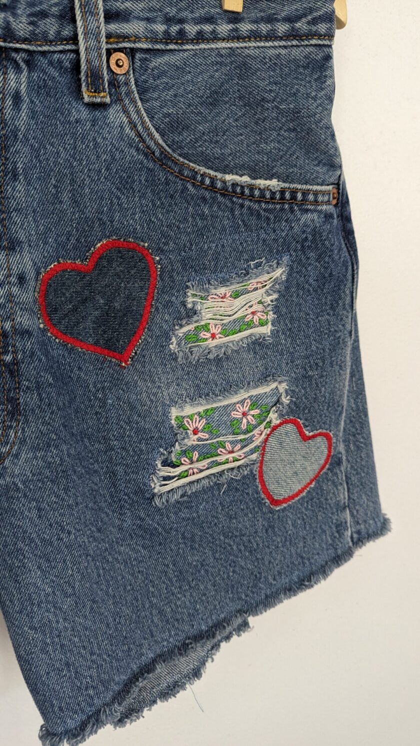 a pair of denim shorts with hearts on them.