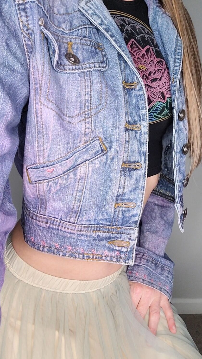 a woman wearing a denim jacket and tulle skirt.