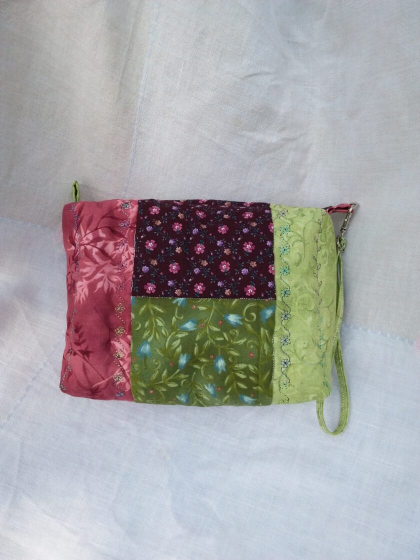 A small Cottage Core purse with a patchwork pattern on it.