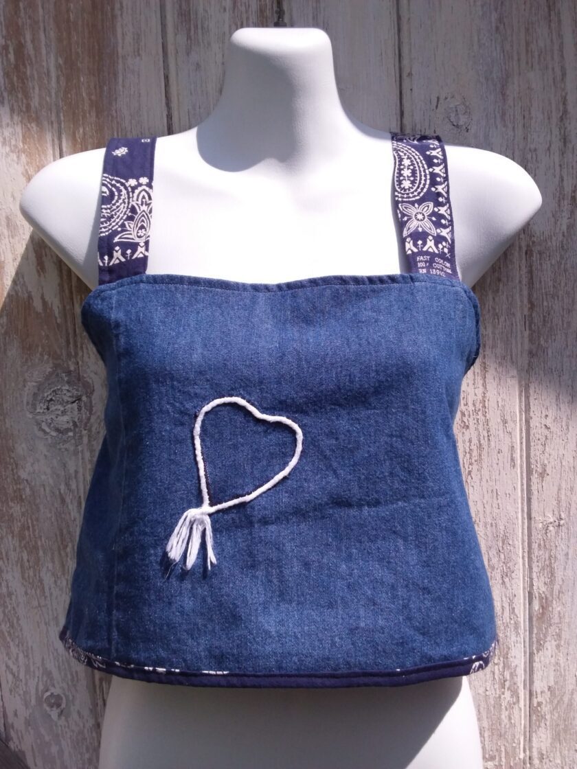 An upcycled blue denim crop top with bandana fabric straps and a heart on it.