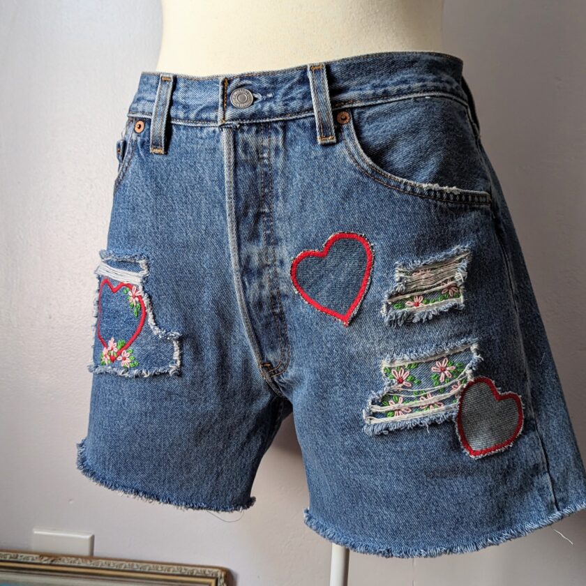a pair of denim shorts with hearts on them.