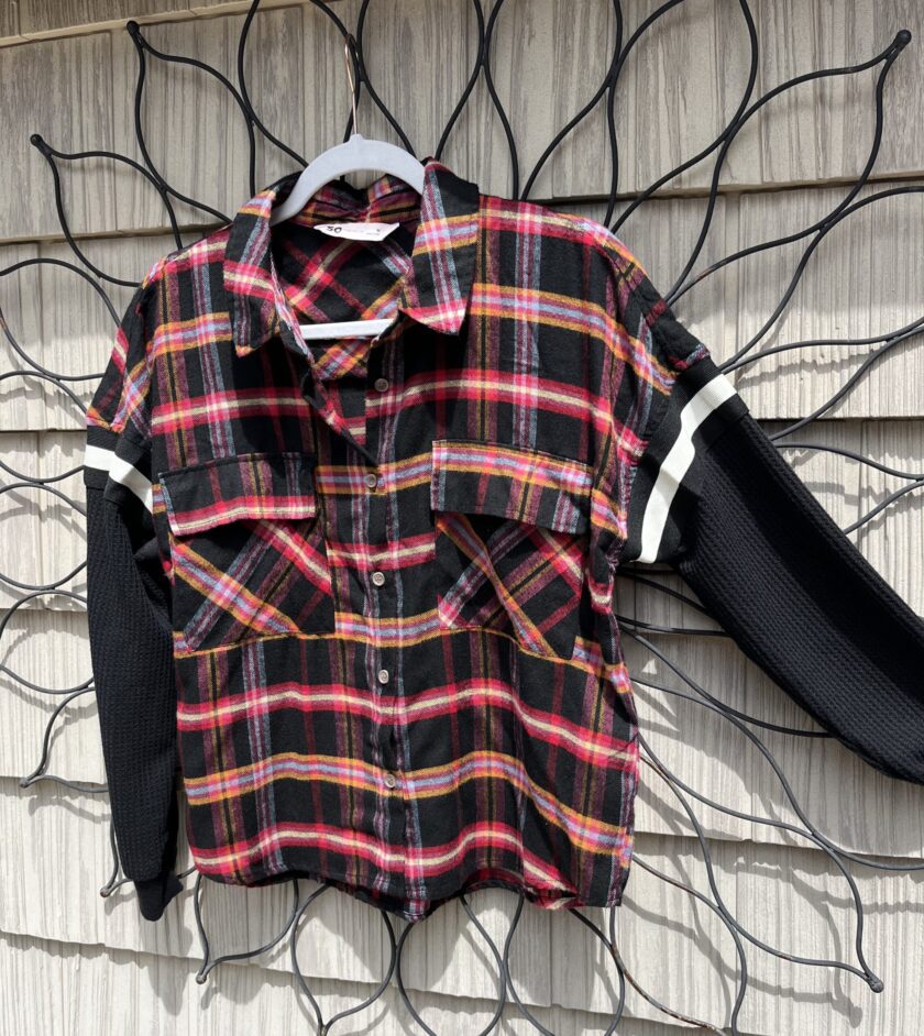 A black and red plaid shirt hanging on a wall.