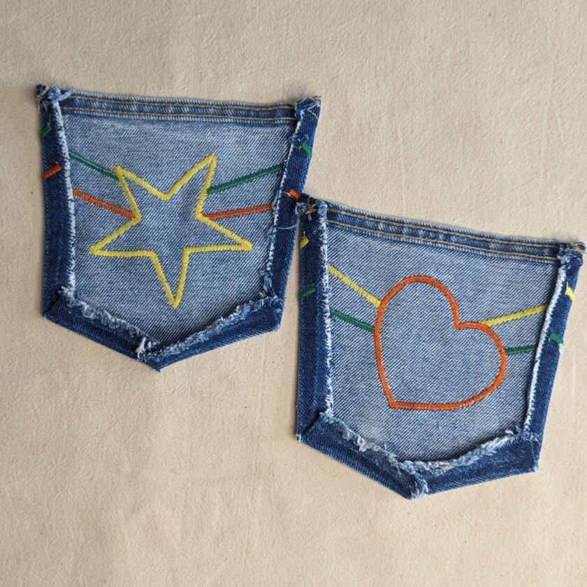 A pair of jeans with a star and heart embroidered on them.