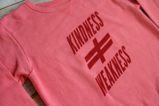A pink sweatshirt that says kindness weakness.
