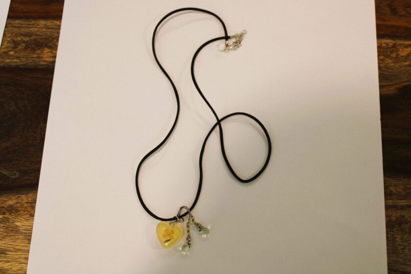 A necklace with a yellow heart on it.