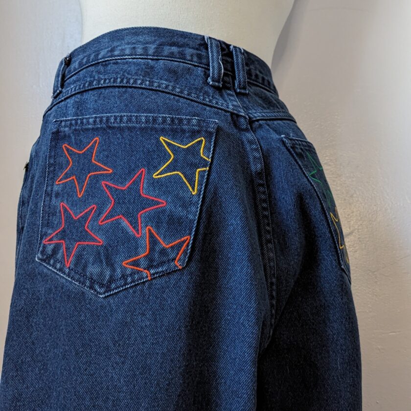 A pair of blue jeans with stars embroidered on them.