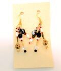 A pair of earrings with red, black and white beads.