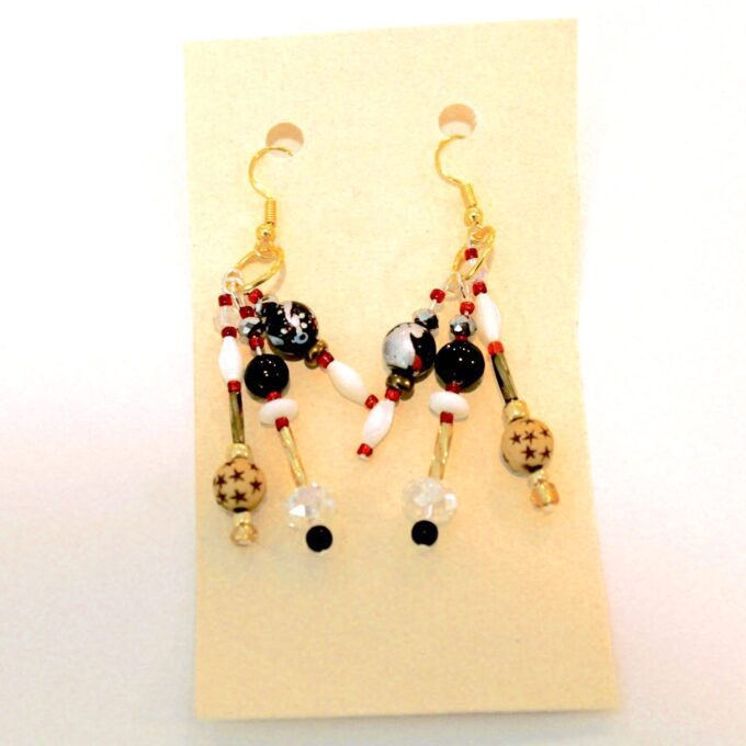 A pair of earrings with red, black and white beads.