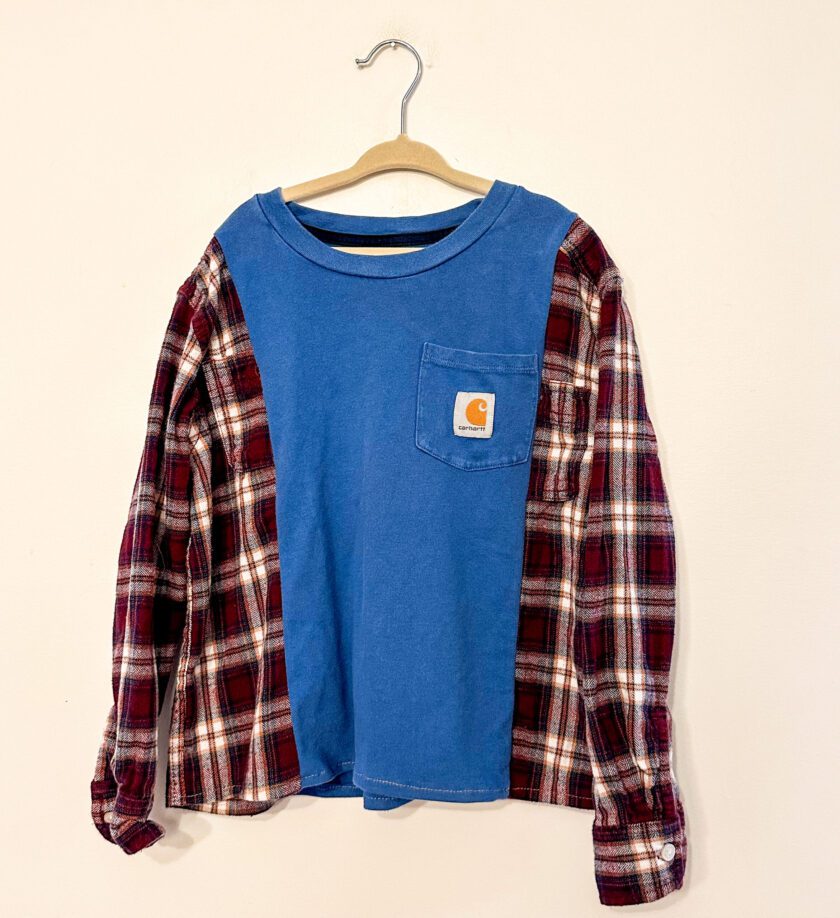 A blue and red plaid shirt hanging on a hanger.