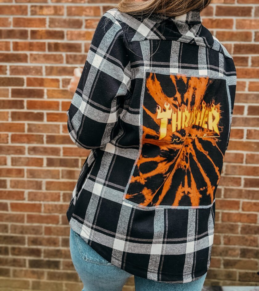 A woman wearing a black and orange flannel shirt.