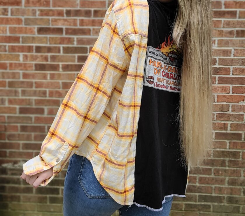 A blonde woman wearing a plaid shirt and jeans.