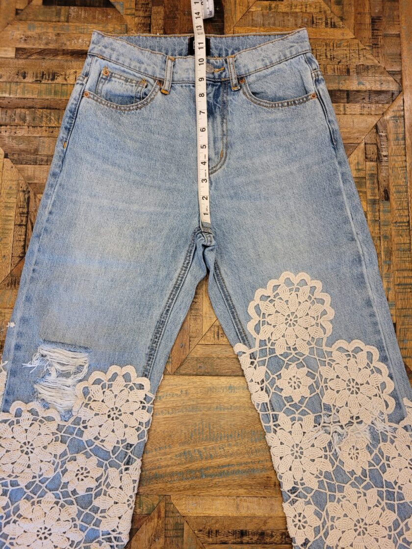 A pair of jeans with lace on them.