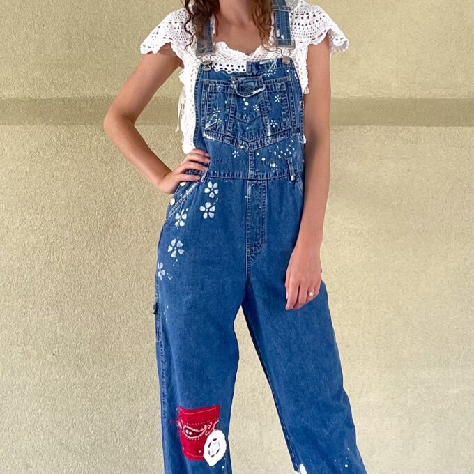 A woman in overalls posing for a photo.