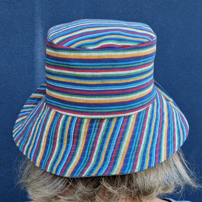 The back of a woman wearing a colorful striped hat.