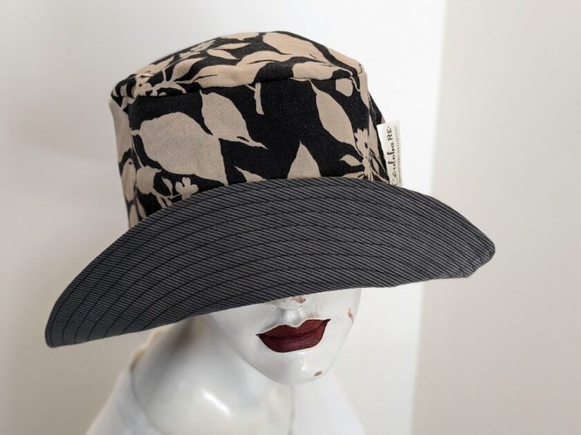 A mannequin wearing a black and white hat.