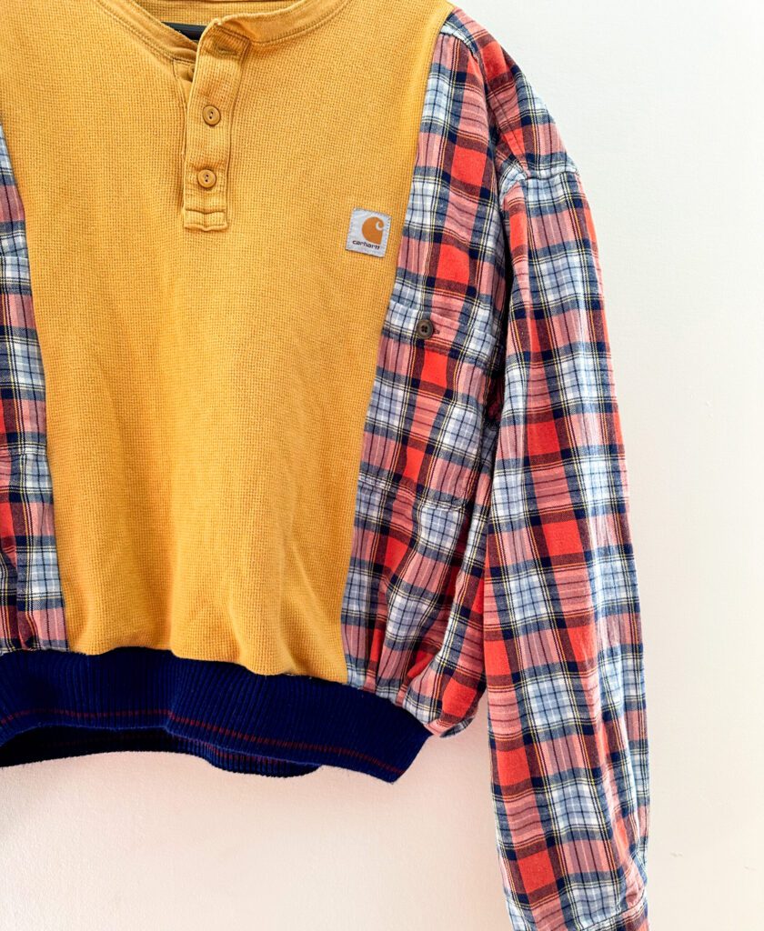 A yellow and blue plaid shirt hanging on a wall.