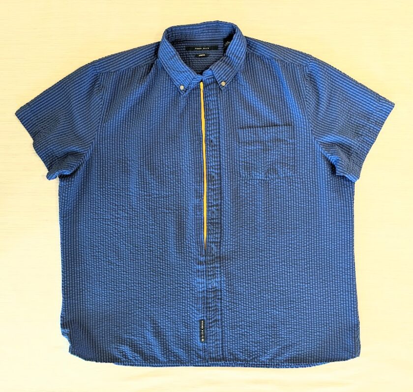 A blue shirt with yellow zippers on it.