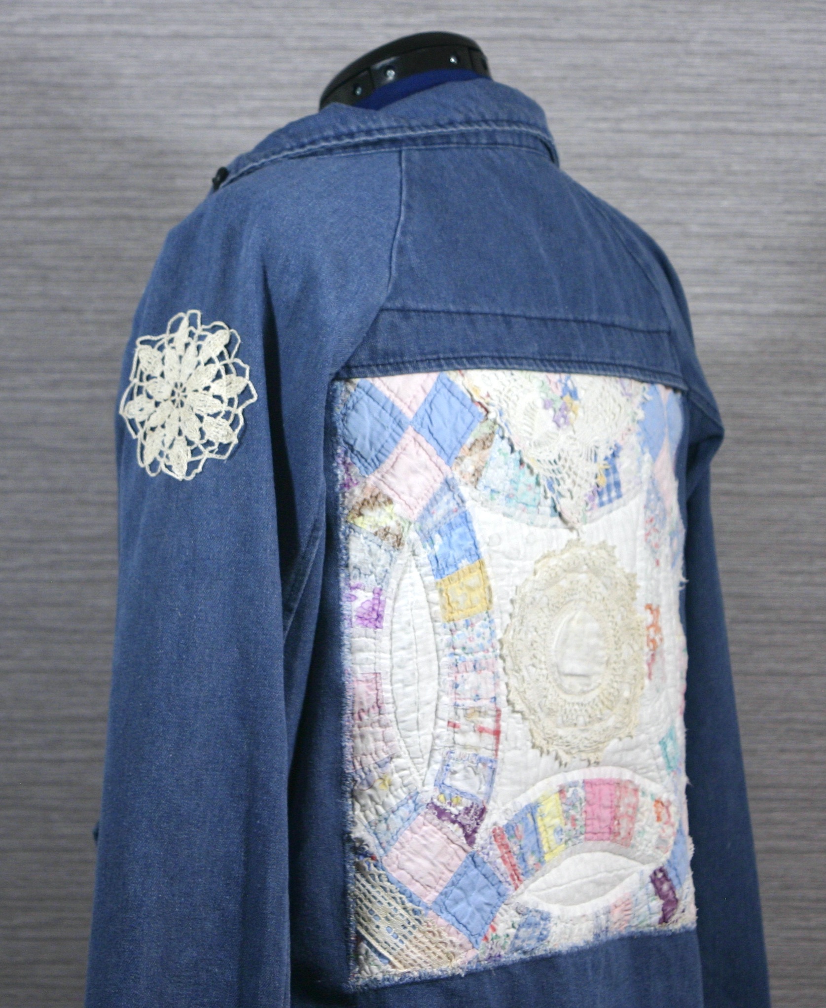 The back of a denim jacket with patchwork on it.