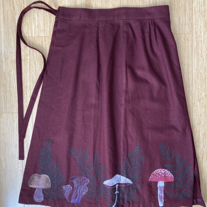 A burgundy skirt with mushrooms on it.
