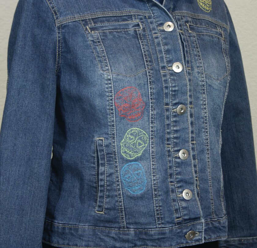 A denim jacket with colorful skulls on it.