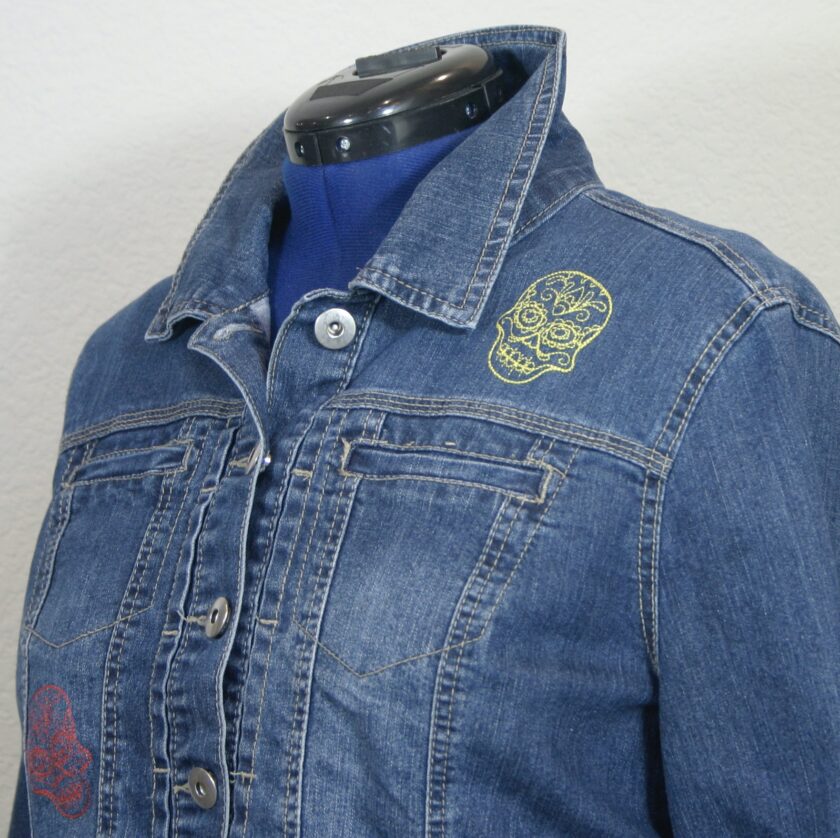 A denim jacket with embroidered designs on it.
