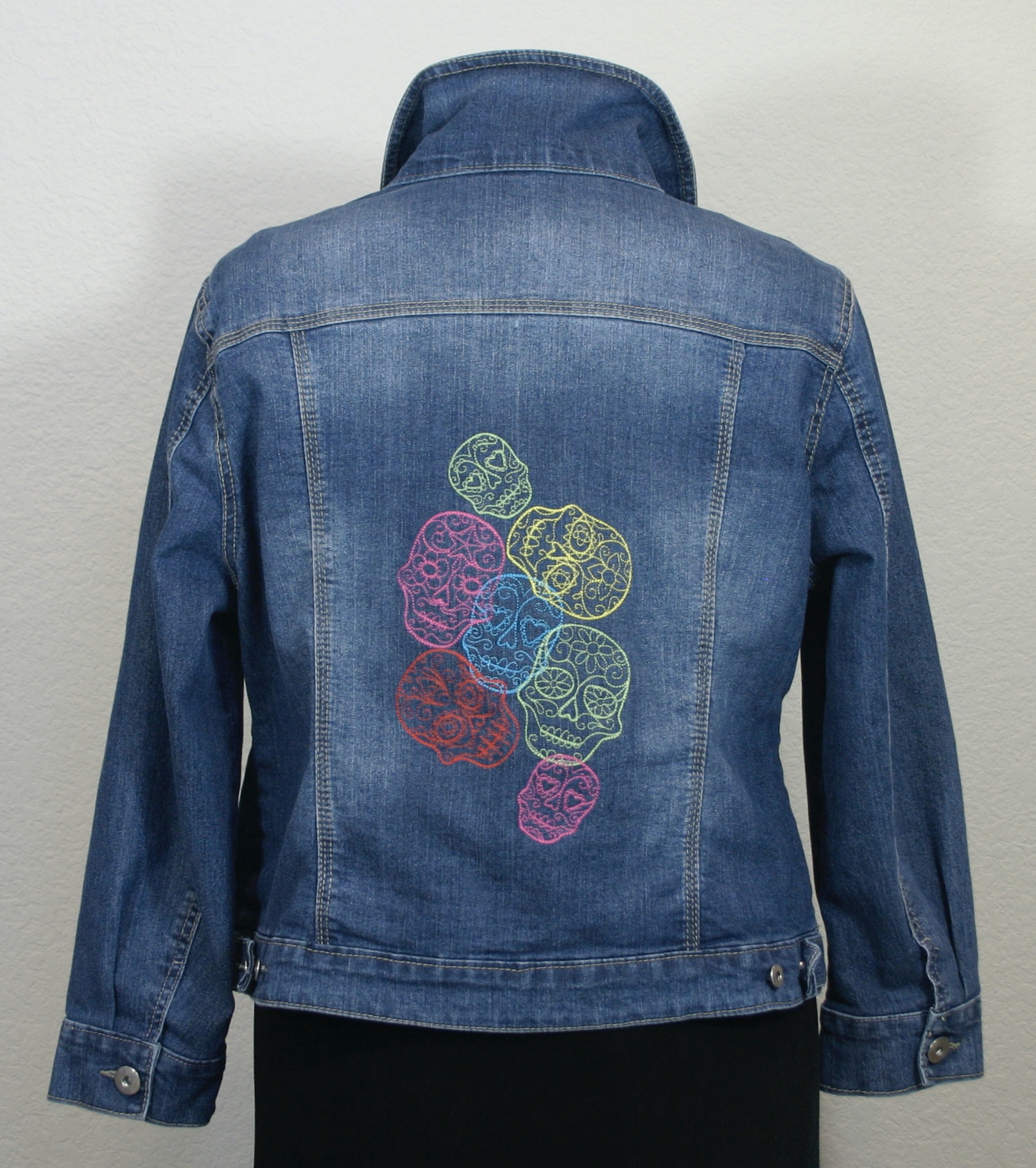A denim jacket with a colorful embroidered design.
