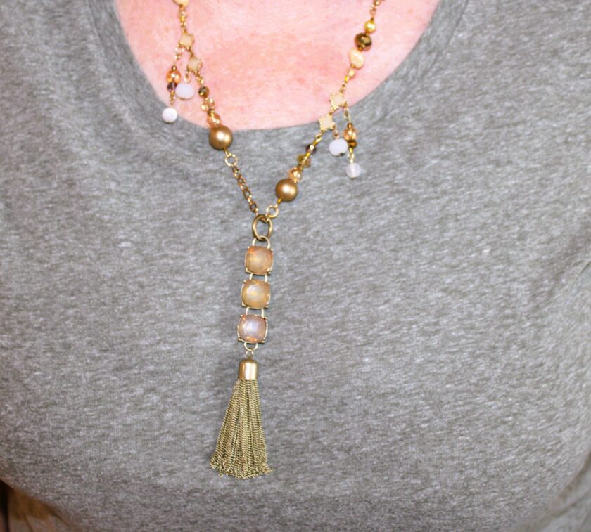 A woman wearing a necklace with a tassel.