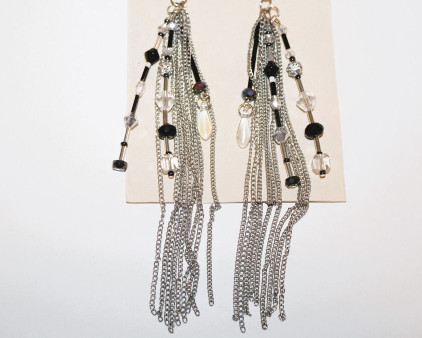A pair of black , crystal and silver tassel earrings .